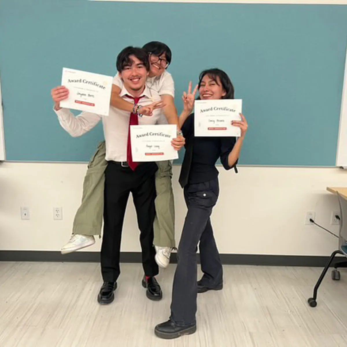 Jayden and two teammates holding their award certificates